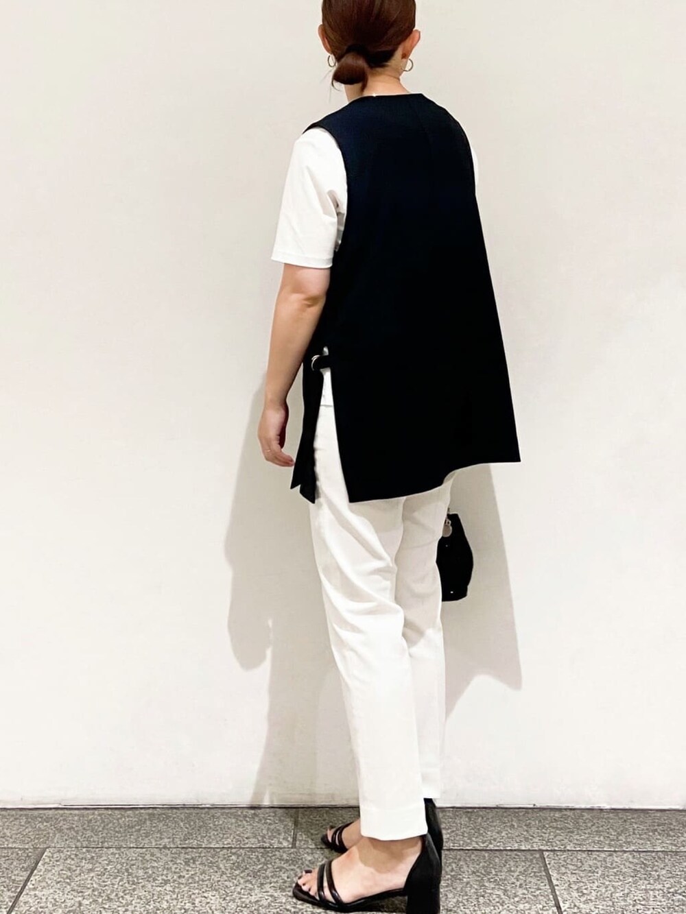 ホワイト系のTシャツ/カットソー、ブラック系のベスト、ブラック系のショルダーバッグを着用したレディースの夏コーディネートの6枚目の写真