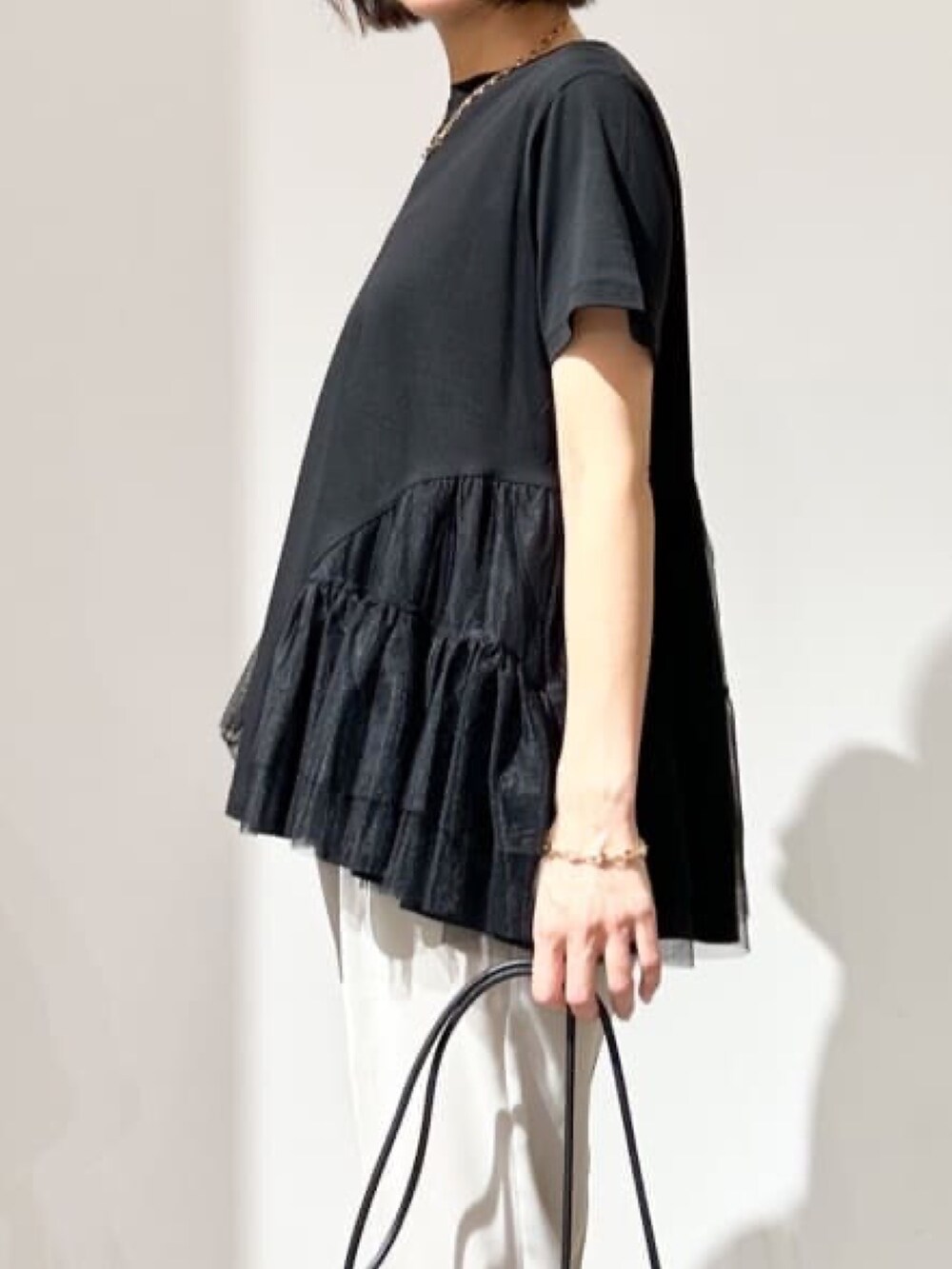 グレー系のその他パンツ、ブラック系のショルダーバッグ、ブラック系のパンプスを着用したレディースの春コーディネートの4枚目の写真