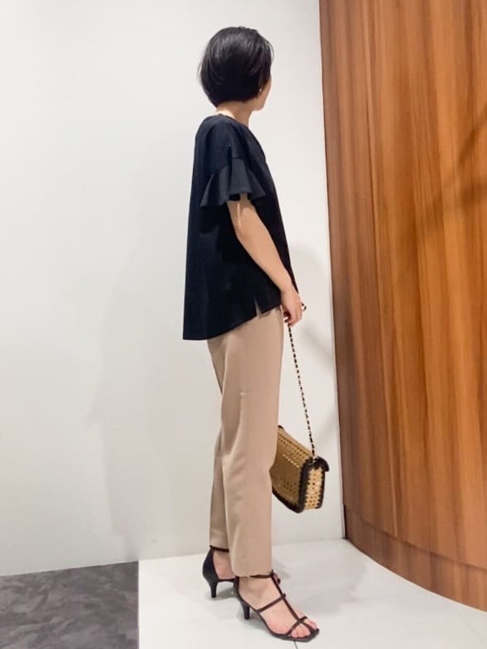 ブラック系のTシャツ/カットソー、ブラック系のショルダーバッグ、ブラック系のサンダルを着用したレディースの夏コーディネートの2枚目の写真