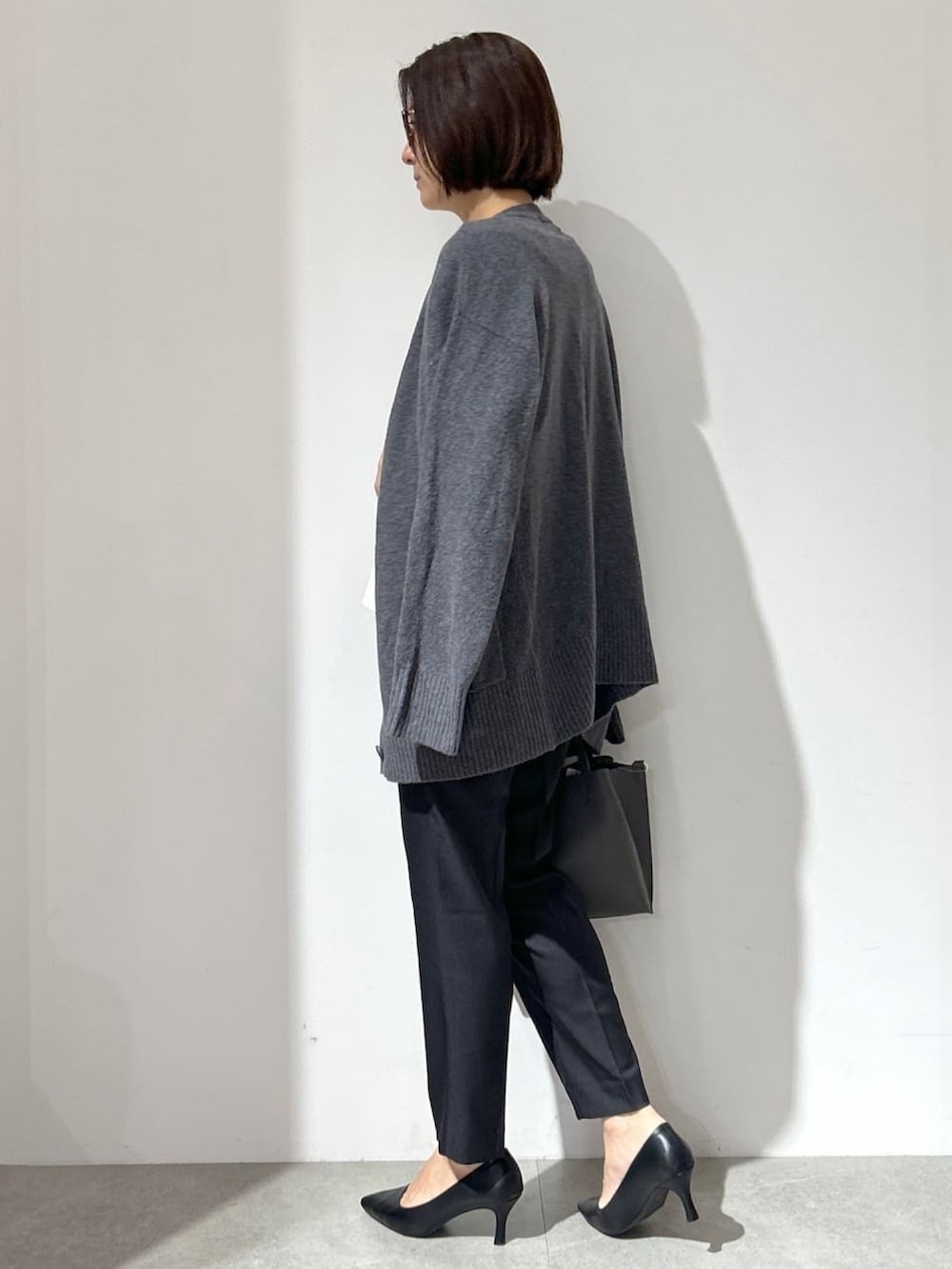 ホワイト系のTシャツ/カットソー、グレー系のカーディガン/ボレロ、ブラック系のその他パンツを着用したレディースの秋コーディネートの2枚目の写真