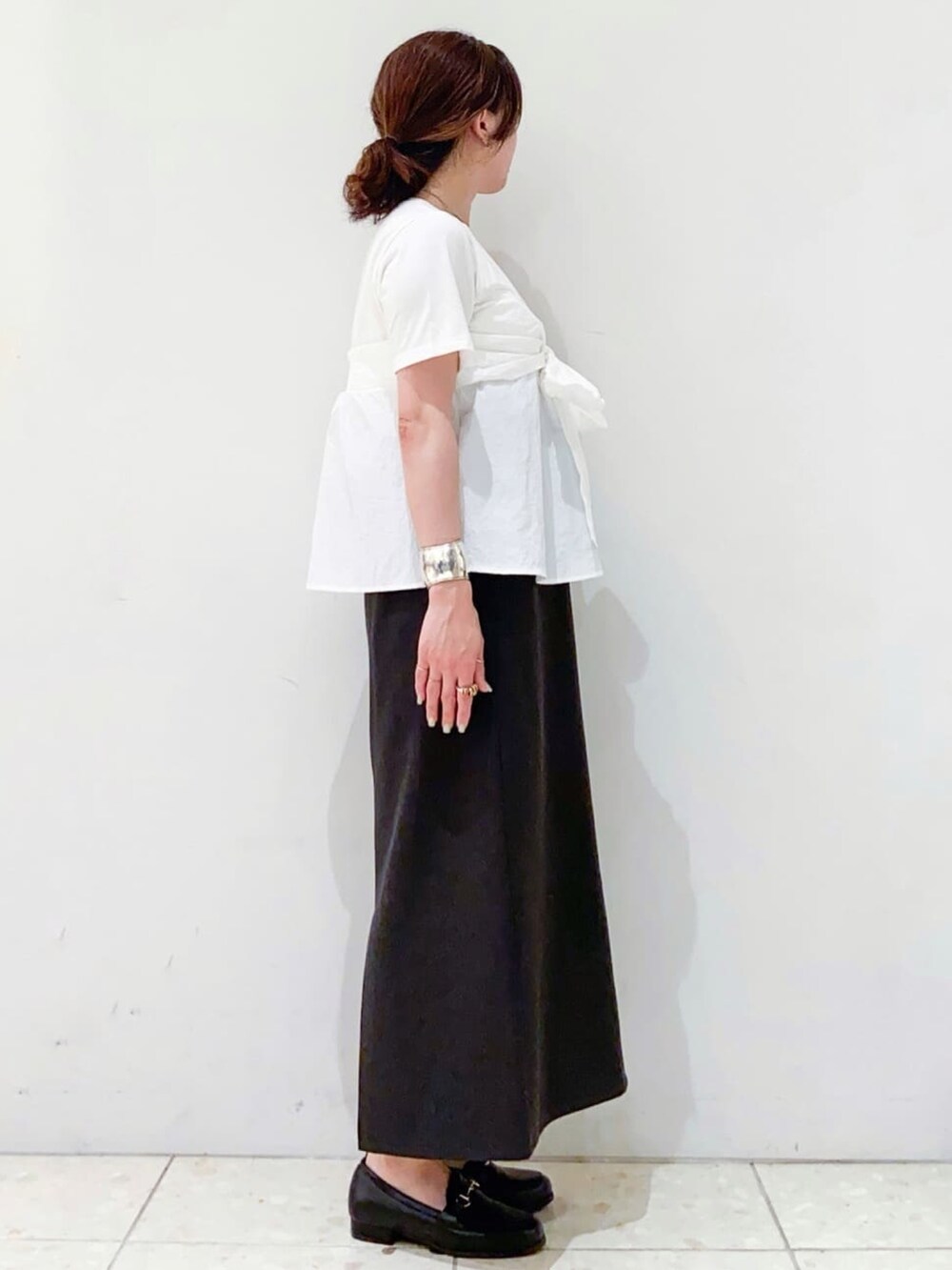 ホワイト系のTシャツ/カットソー、グレー系のスカート、シルバー系のトートバッグを着用したレディースの夏コーディネートの2枚目の写真