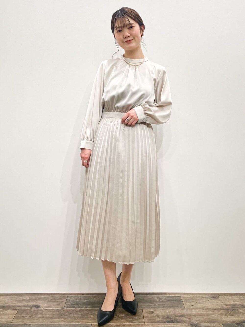 ホワイト系のノーカラージャケット、ベージュ系のワンピース、ブラック系のトートバッグを着用したレディースの冬コーディネートの4枚目の写真