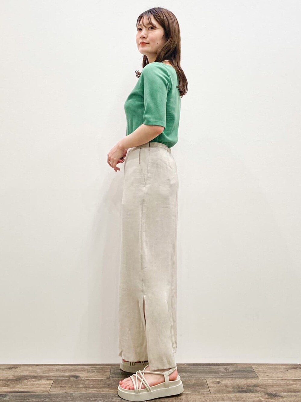 ベージュ系のスカート、ベージュ系のテーラードジャケット、グリーン系のTシャツ/カットソーを着用したレディースの春コーディネートの3枚目の写真