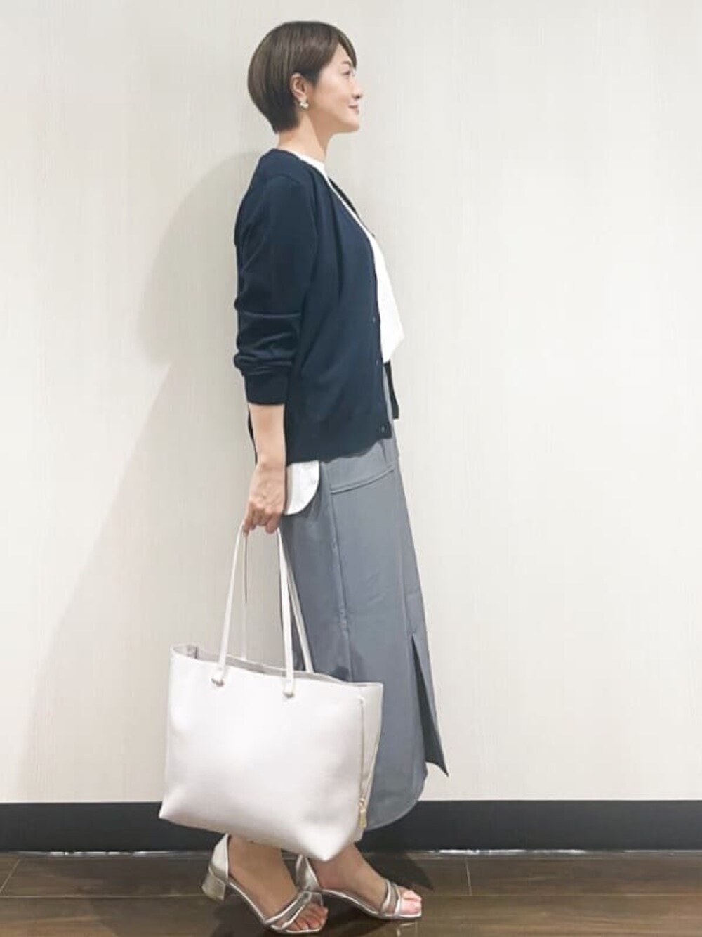ブルー系のカーディガン/ボレロ、ホワイト系のTシャツ/カットソー、グレー系のスカートを着用したレディースの夏コーディネートの2枚目の写真