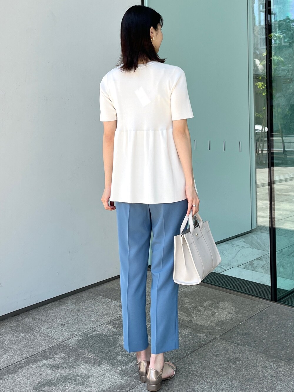ホワイト系のニット/セーター、ブルー系のその他パンツ、ゴールド系のサンダルを着用したレディースの春コーディネートの3枚目の写真