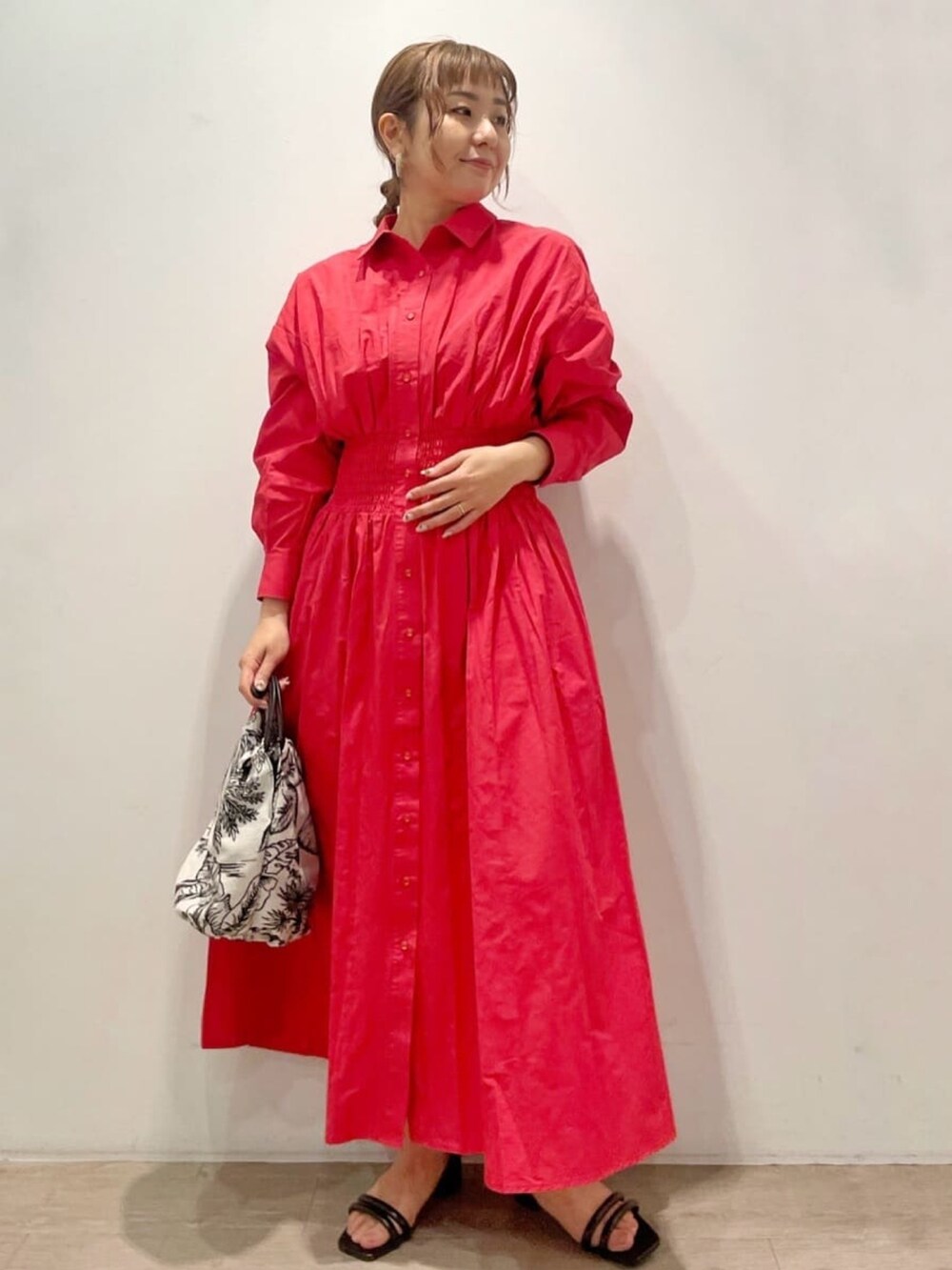 レッド系のワンピース、ホワイト系のハンドバッグ、ブラック系のサンダルを着用したレディースの春コーディネートの4枚目の写真