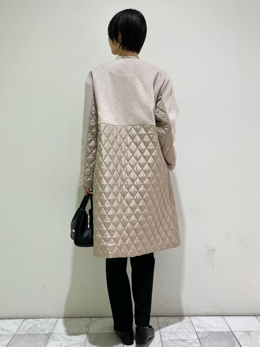 ブラック系のその他パンツ、ブラック系のショルダーバッグ、ブラック系のパンプスを着用したレディースの冬コーディネートの3枚目の写真