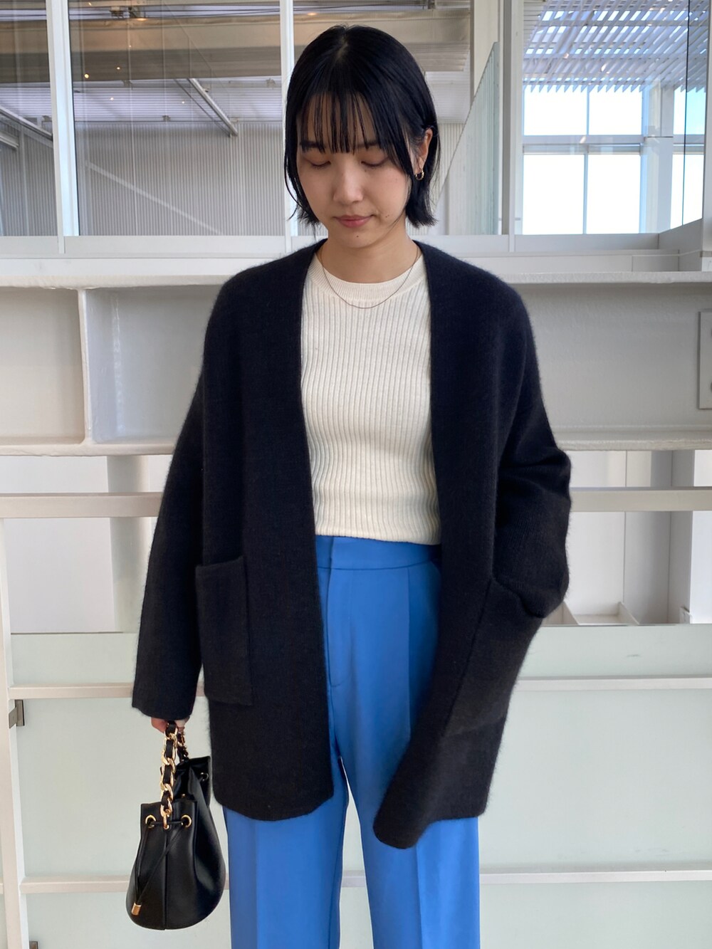 ホワイト系のニット/セーター、グレー系のカーディガン/ボレロ、ブルー系のその他パンツを着用したレディースの秋コーディネートの4枚目の写真