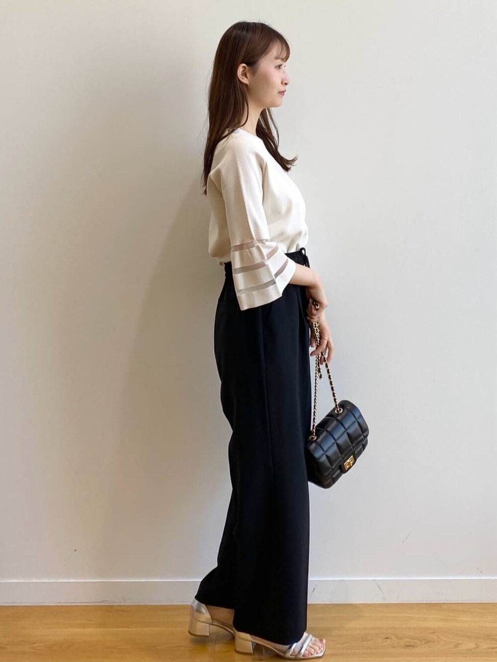 ホワイト系のニット/セーター、ブラック系のその他パンツ、ブラック系のショルダーバッグを着用したレディースの春コーディネートの3枚目の写真