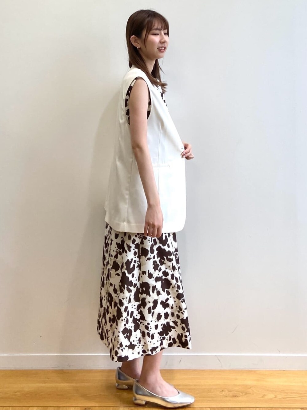 ブラウン系のワンピース、ベージュ系のベスト、シルバー系のパンプスを着用したレディースの夏コーディネートの3枚目の写真