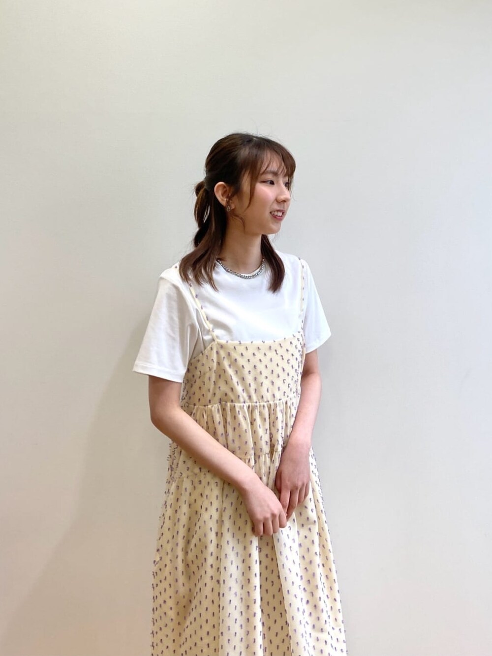 ホワイト系のワンピース、ホワイト系のTシャツ/カットソー、シルバー系のサンダルを着用したレディースの春コーディネートの5枚目の写真