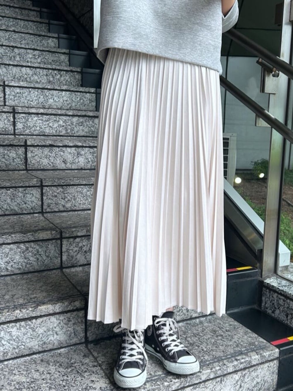 ホワイト系のスカート、グレー系のパーカーを着用したレディースの秋コーディネートの4枚目の写真