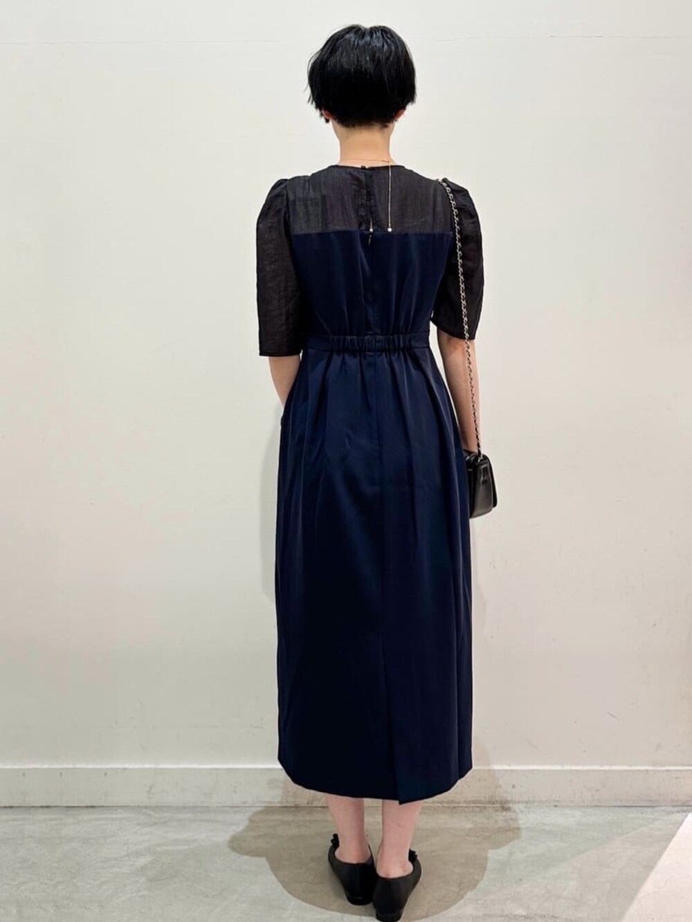 ブラック系のショルダーバッグ、ブラック系のその他シューズ、ブルー系のワンピースを着用したレディースの秋コーディネートの3枚目の写真