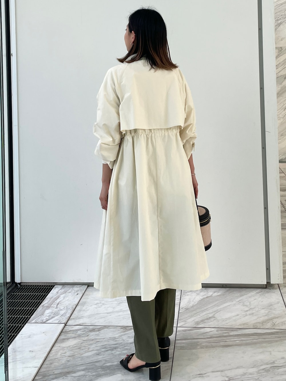 ホワイト系のその他アウター、ホワイト系のニット/セーター、グリーン系のその他パンツを着用したレディースの春コーディネートの2枚目の写真