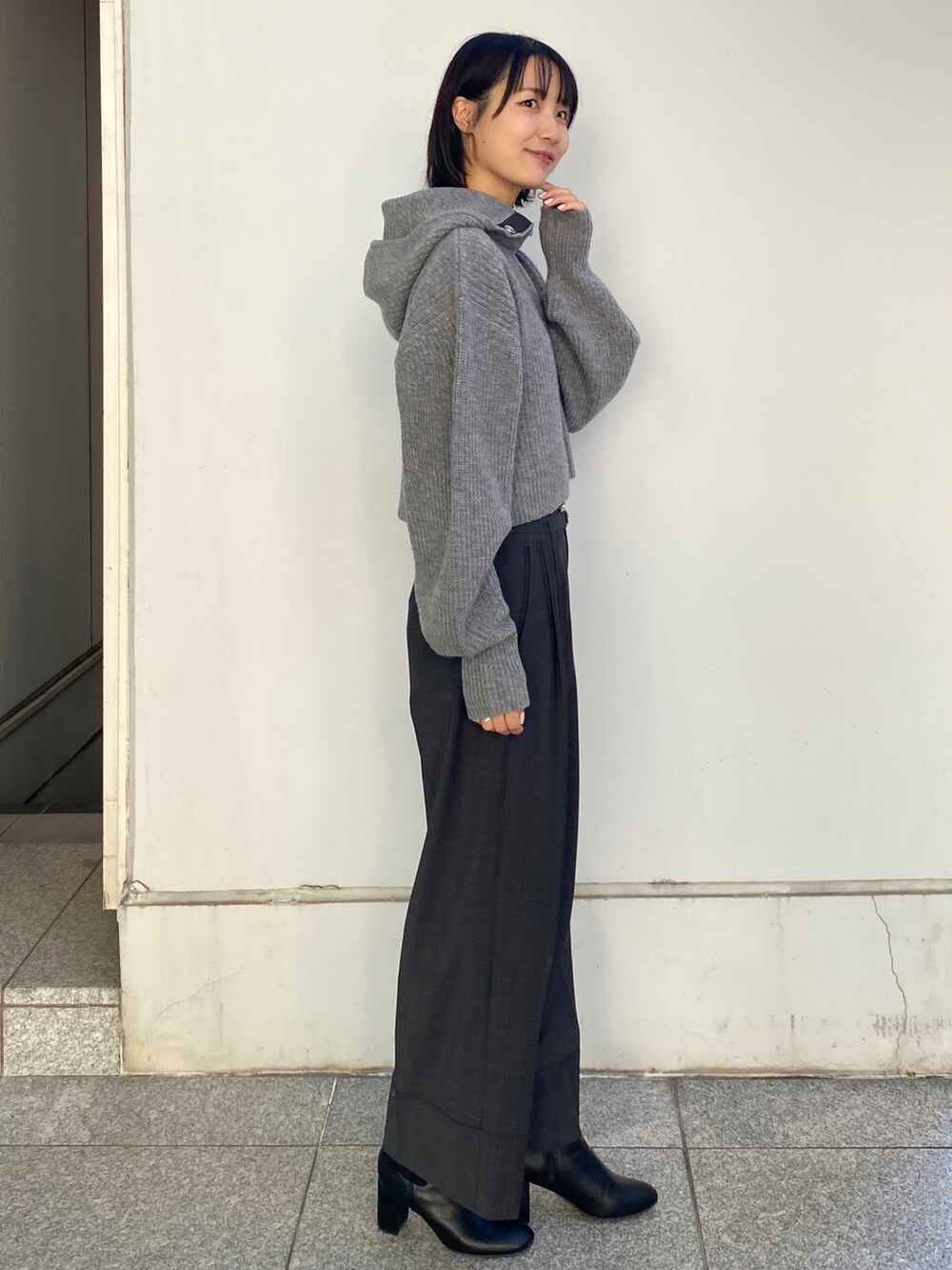 グレー系のその他パンツ、グレー系のニット/セーター、ブラック系のブーツを着用したレディースの秋コーディネートの2枚目の写真