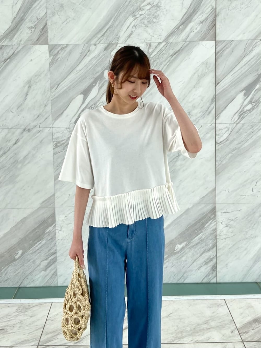 ホワイト系のTシャツ/カットソー、ブルー系のデニムパンツ、ホワイト系のハンドバッグを着用したレディースの夏コーディネートの6枚目の写真