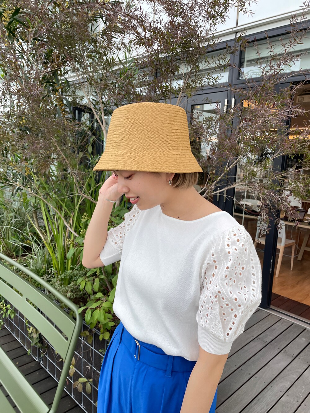 ホワイト系のニット/セーター、ブルー系のその他パンツ、ホワイト系のショルダーバッグを着用したレディースの春コーディネートの2枚目の写真