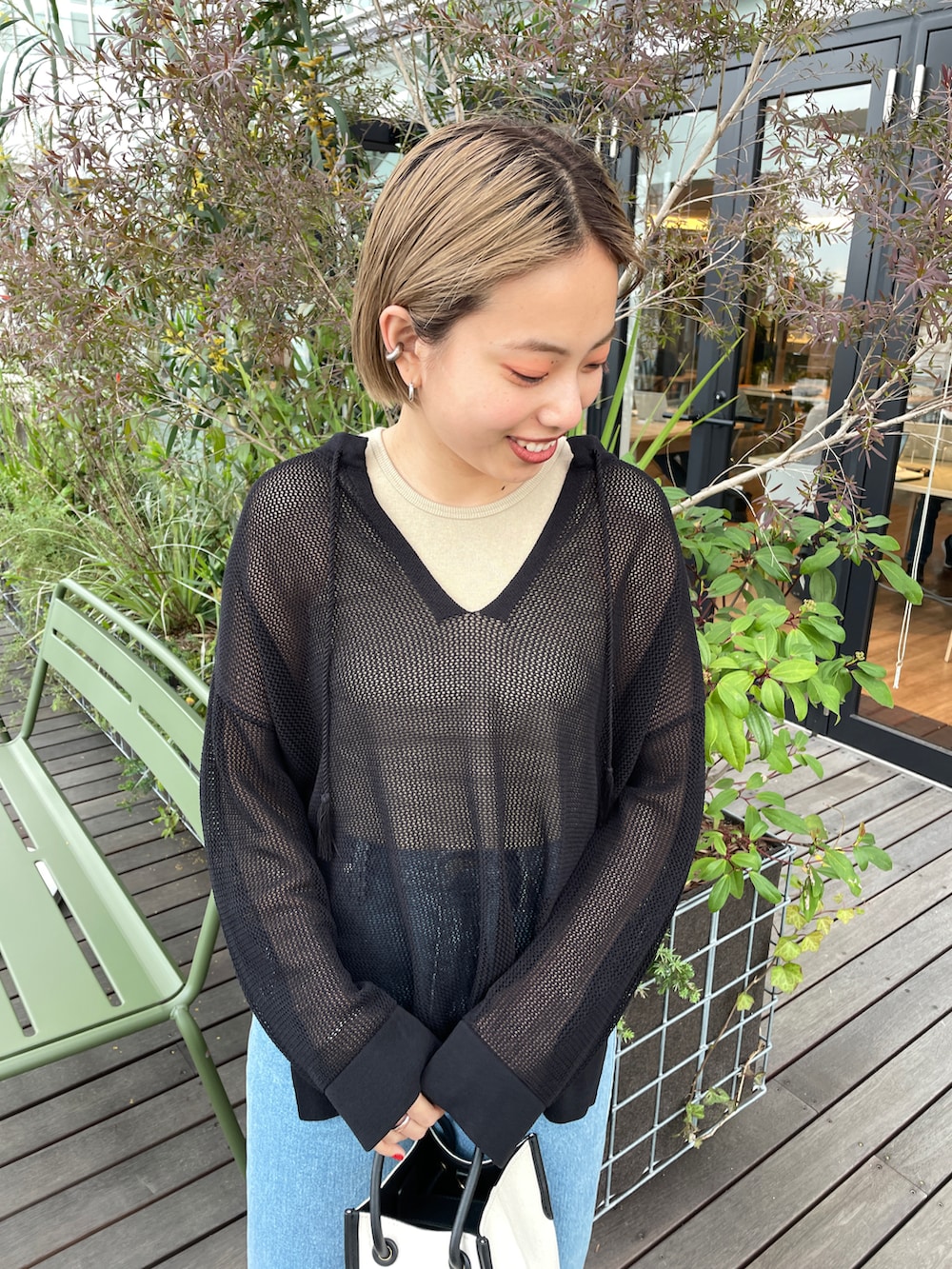 ブラック系のニット/セーター、ベージュ系のタンクトップ、ブルー系のその他パンツを着用したレディースの春コーディネートの2枚目の写真