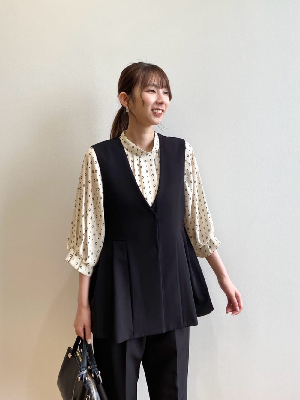 ブラック系のその他パンツ、ブラック系のパンプス、ホワイト系のシャツ/ブラウスを着用したレディースの夏コーディネートの6枚目の写真