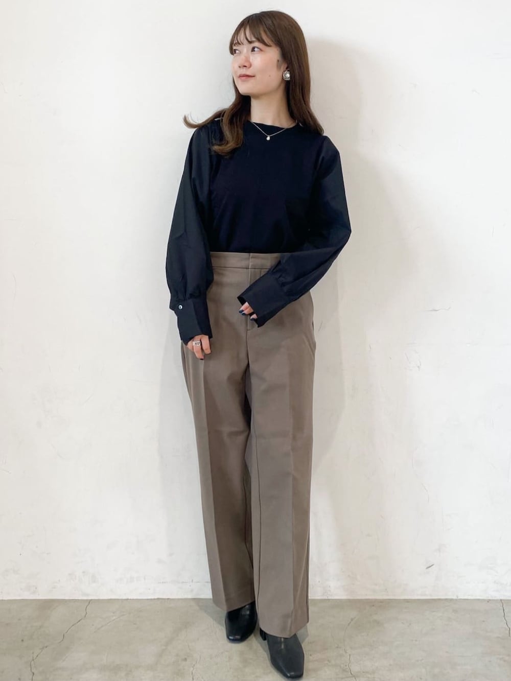 ブラウン系のその他パンツ、ベージュ系のノーカラーコート、ブラック系のニット/セーターを着用したレディースの秋コーディネートの4枚目の写真