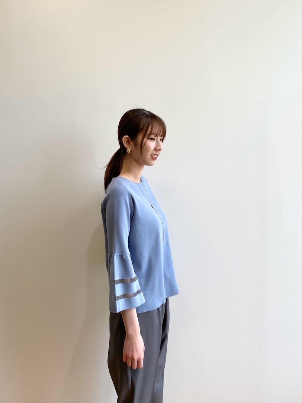 グレー系のその他パンツ、ベージュ系のパンプス、ブルー系のニット/セーターを着用したレディースの秋コーディネートの6枚目の写真