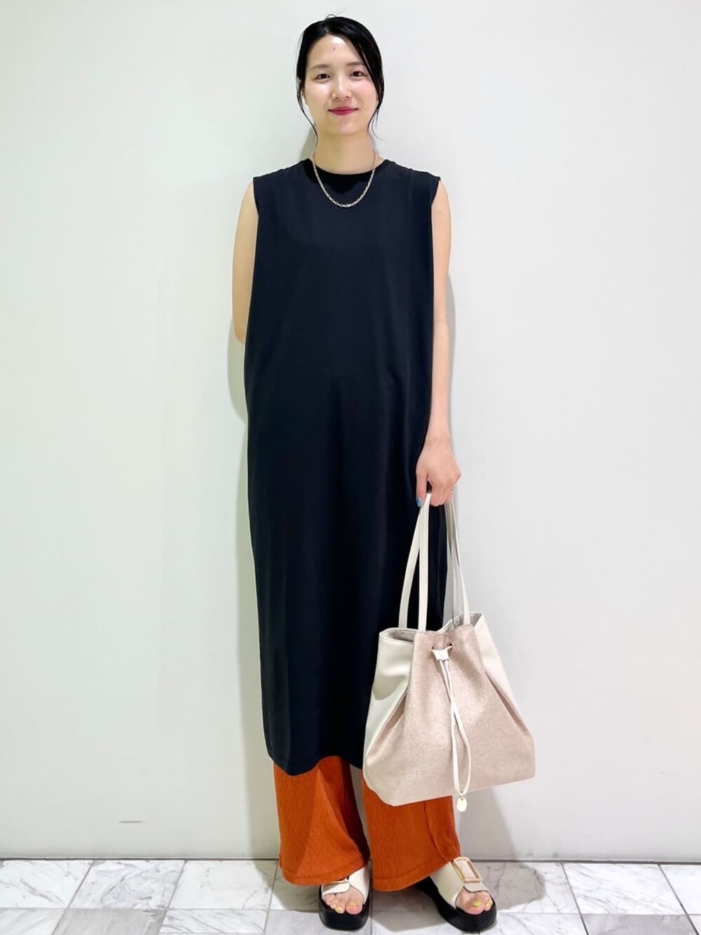 ブラック系のワンピース、レッド系のその他パンツ、ベージュ系のトートバッグを着用したレディースの夏コーディネートの2枚目の写真