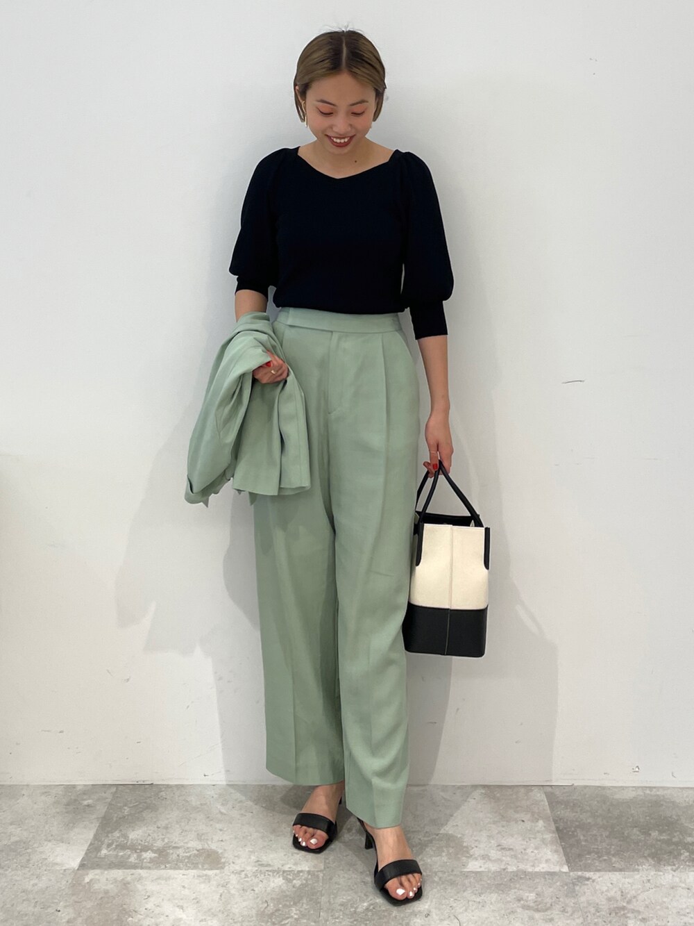 ブラック系のニット/セーター、グリーン系のテーラードジャケット、グリーン系のその他パンツを着用したレディースの春コーディネートの3枚目の写真