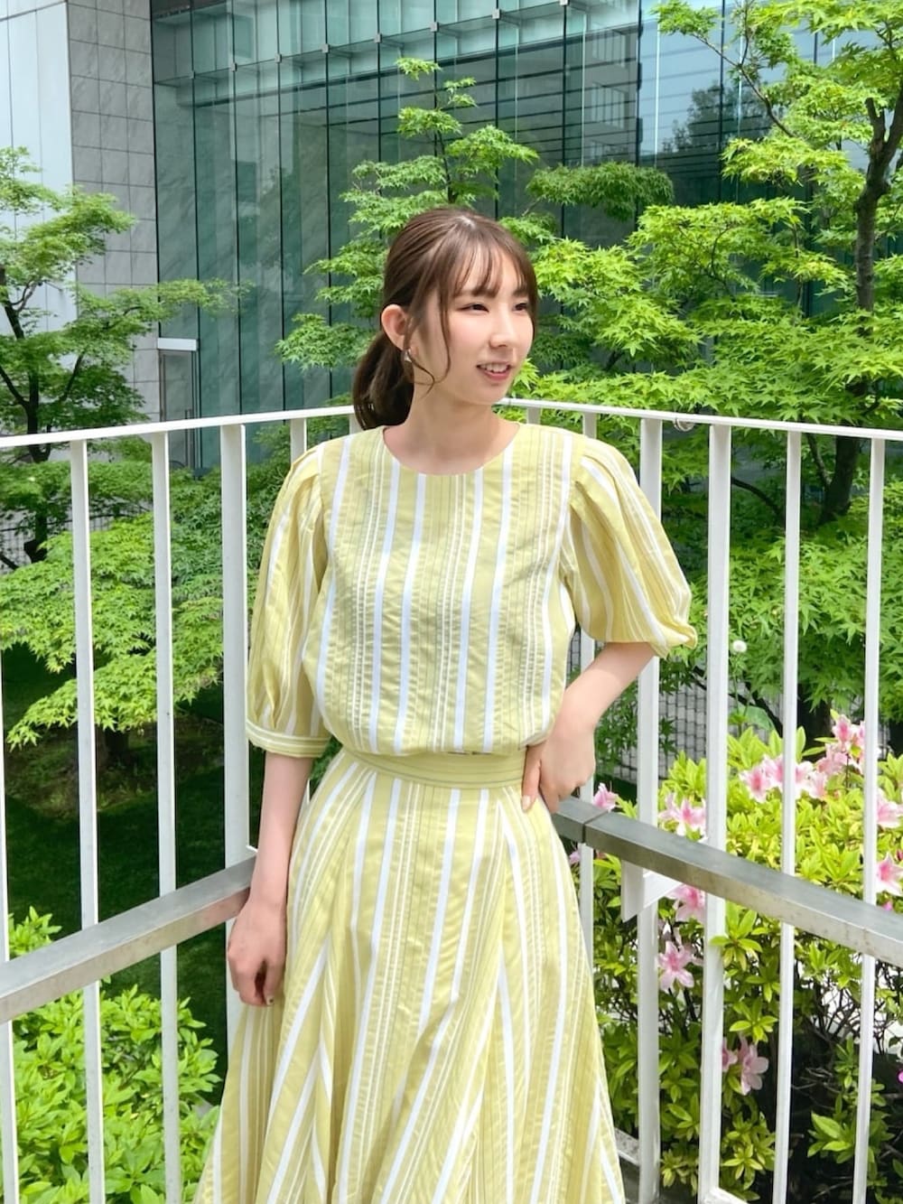 イエロー系のシャツ/ブラウス、イエロー系のスカート、シルバー系のサンダルを着用したレディースの春コーディネートの7枚目の写真