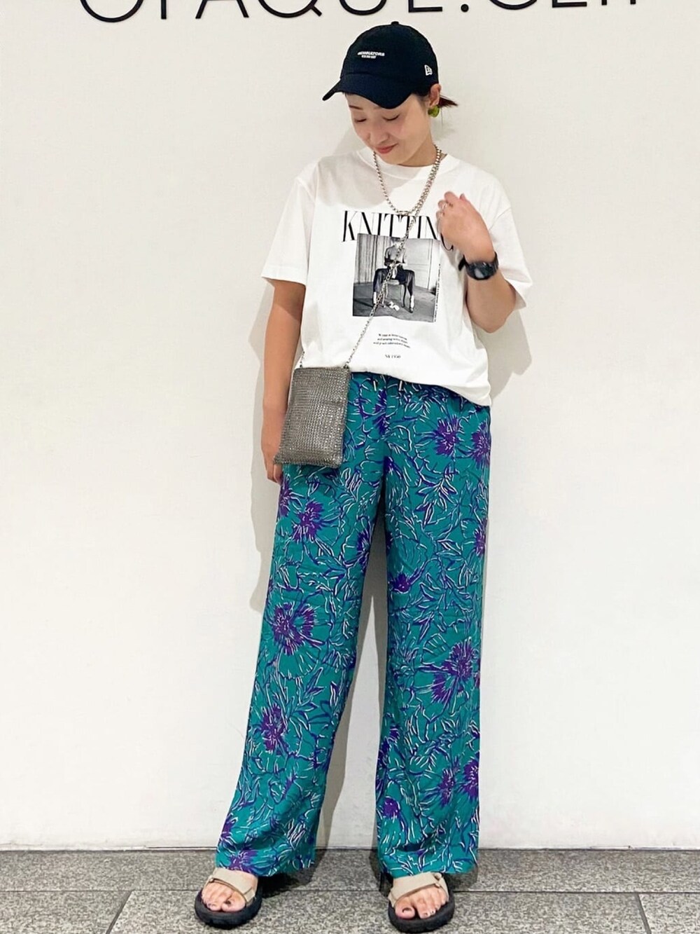 グレー系のショルダーバッグ、グリーン系のその他パンツ、ホワイト系のTシャツ/カットソーを着用したレディースの夏コーディネートの2枚目の写真