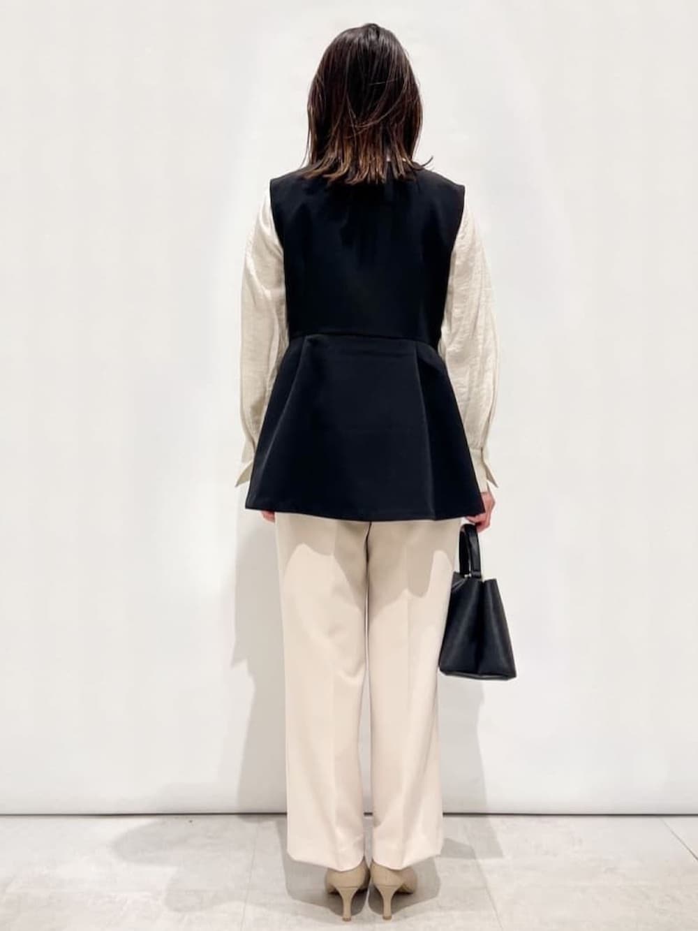 ホワイト系のシャツ/ブラウス、ブラック系のベスト、ベージュ系のその他パンツを着用したレディースの春コーディネートの4枚目の写真