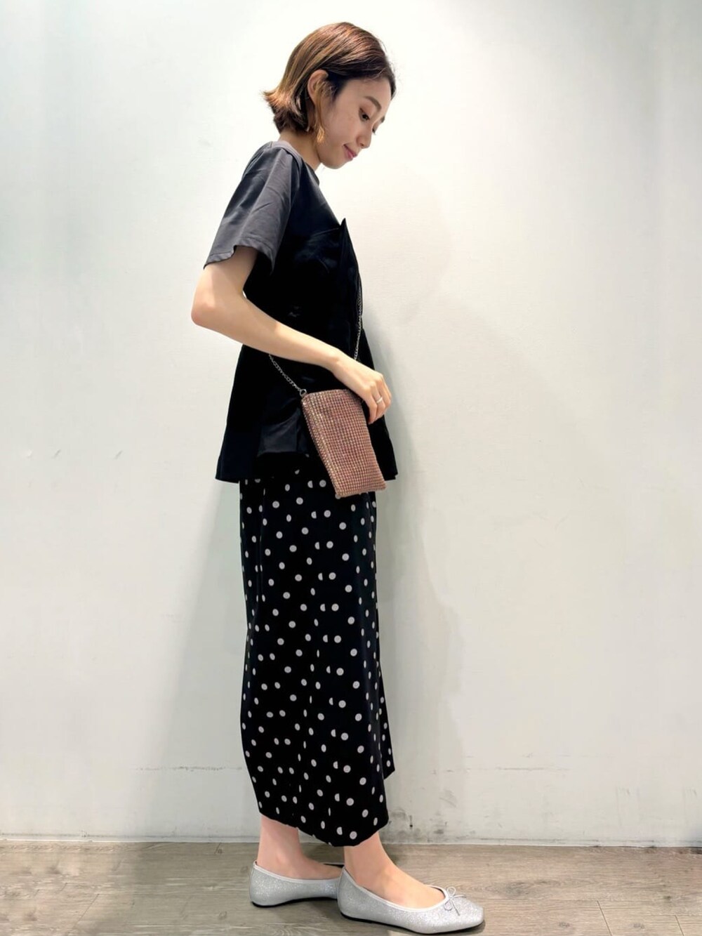 ブラック系のTシャツ/カットソー、シルバー系のパンプス、ブラック系のスカートを着用したレディースの夏コーディネートの2枚目の写真