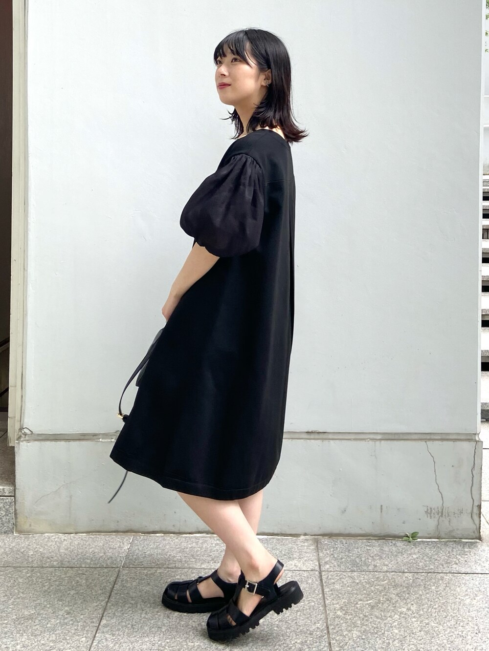 ブラック系のワンピース、ブラック系のサンダル、ブラック系のショルダーバッグを着用したレディースの夏コーディネートの3枚目の写真