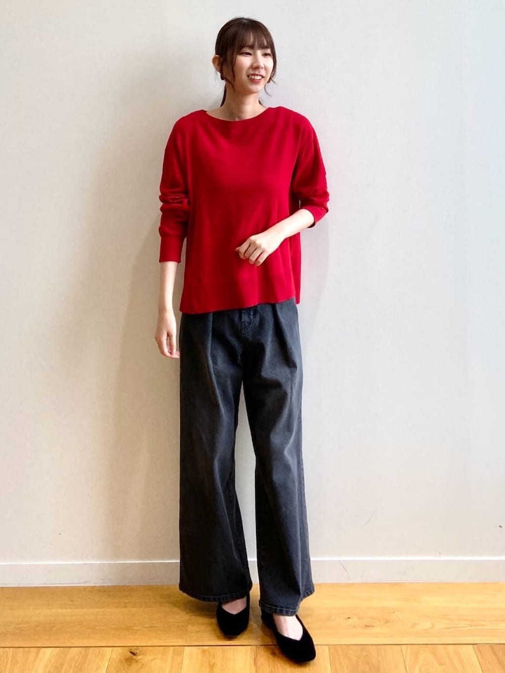 レッド系のニット/セーター、ブラック系のデニムパンツ、ブラック系のパンプスを着用したレディースの秋コーディネートの2枚目の写真