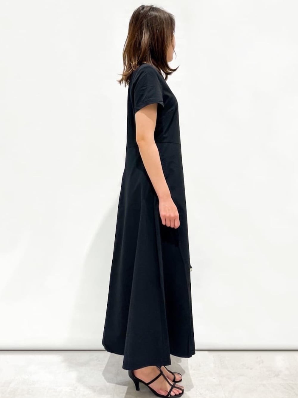 ブラック系のワンピース、ブラック系のトートバッグ、ブラック系のサンダルを着用したレディースの夏コーディネートの2枚目の写真