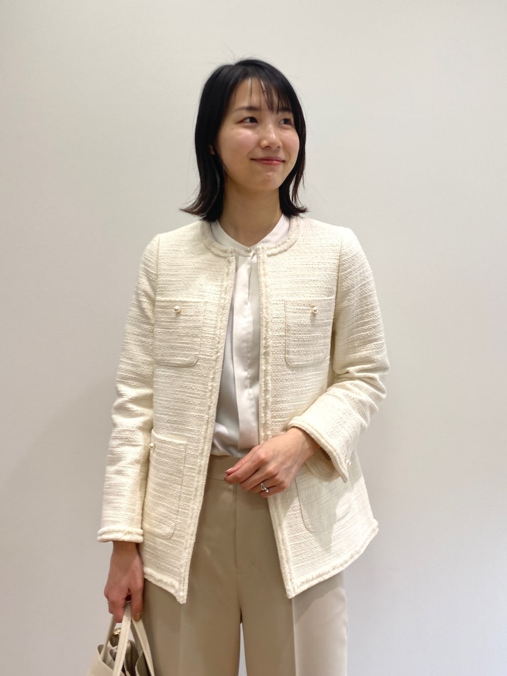 ホワイト系のノーカラージャケット、ベージュ系のその他パンツ、ホワイト系のパンプスを着用したレディースの冬コーディネートの4枚目の写真