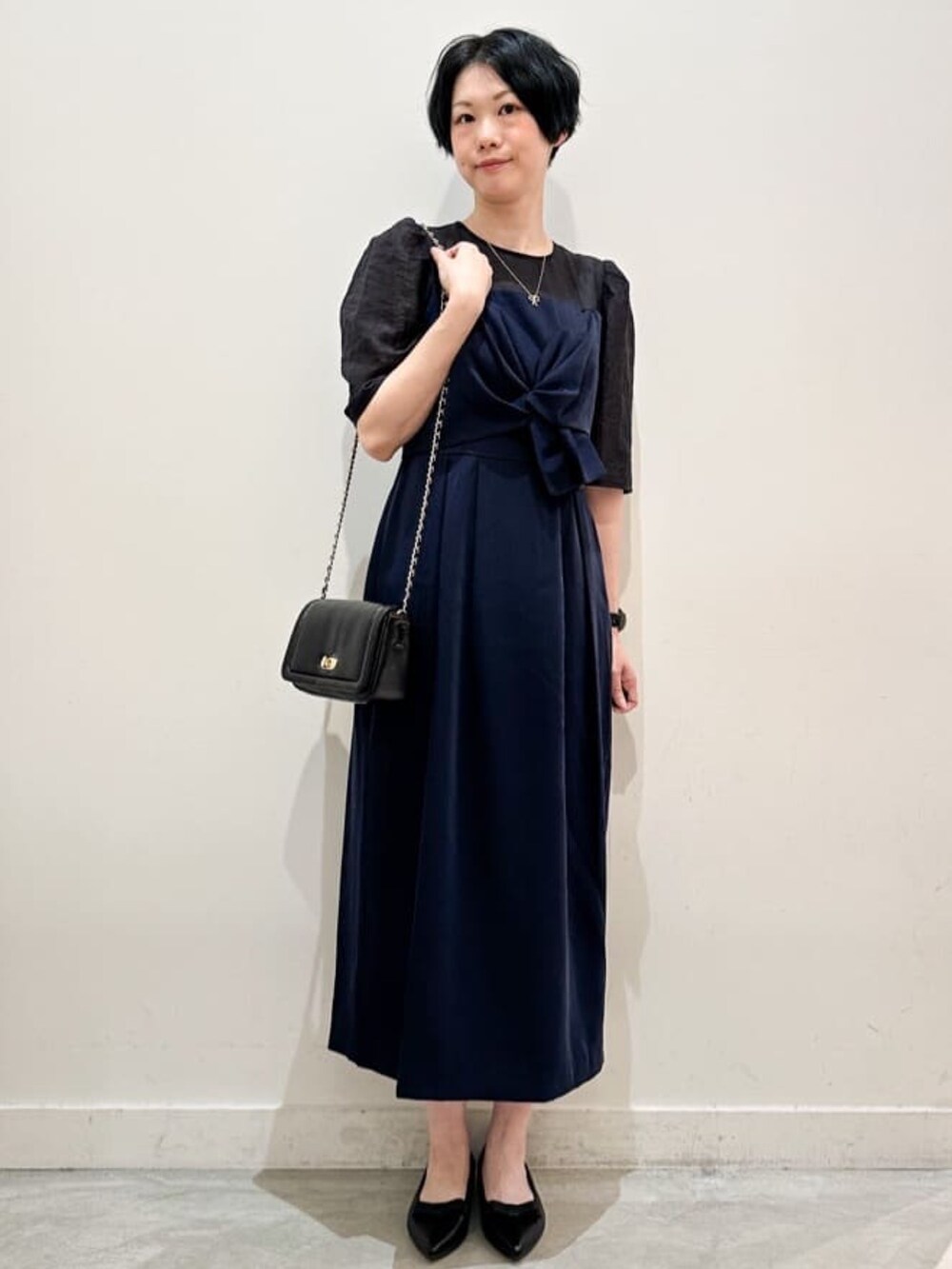 ブラック系のショルダーバッグ、ブラック系のその他シューズ、ブルー系のワンピースを着用したレディースの秋コーディネートの4枚目の写真