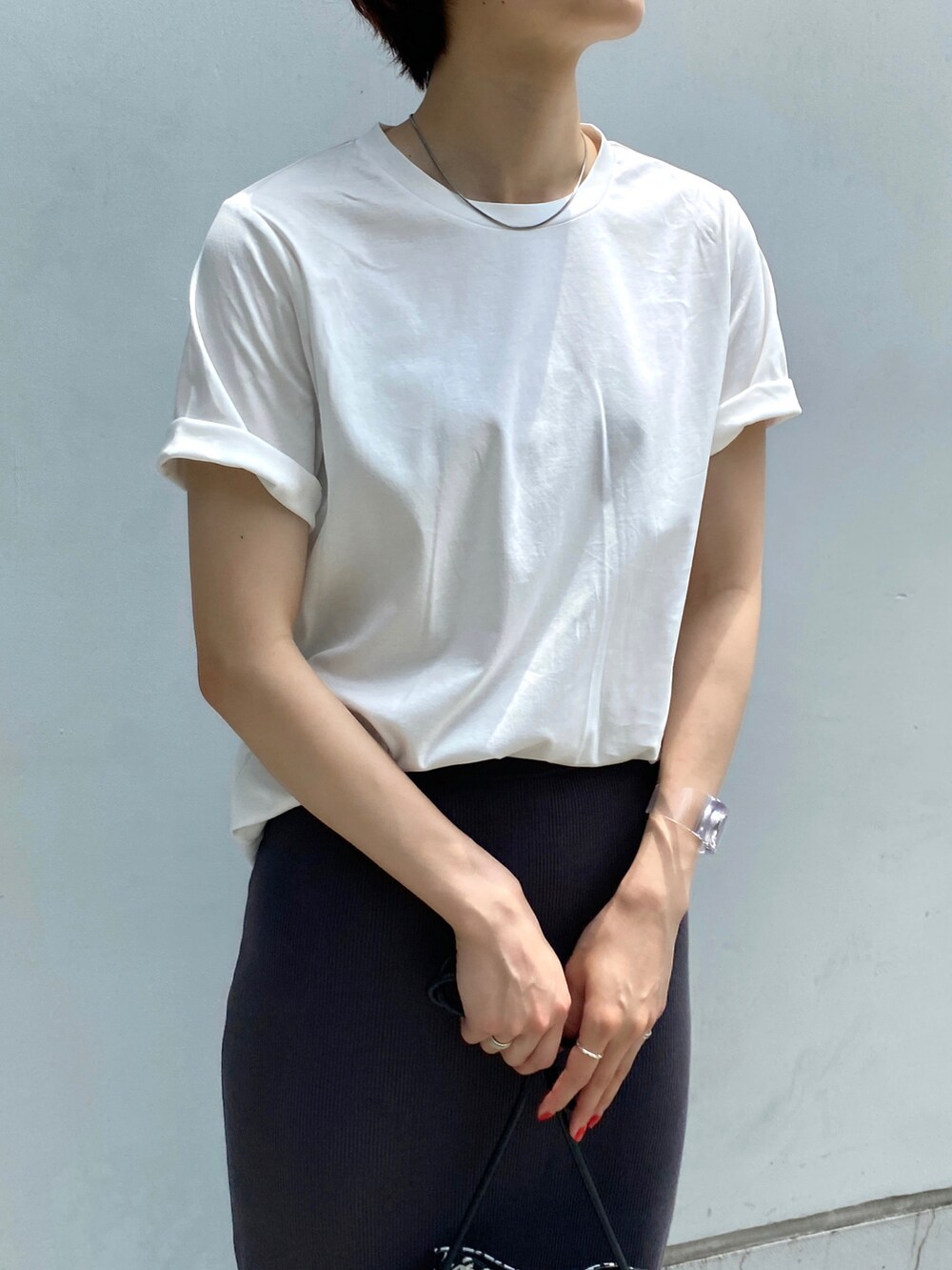 ホワイト系のTシャツ/カットソー、グレー系のスカート、ブラック系のショルダーバッグを着用したレディースの夏コーディネートの4枚目の写真
