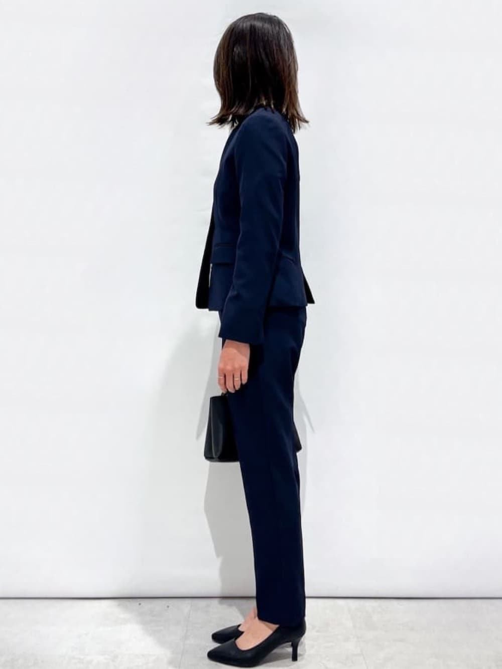 ブルー系のその他パンツ、ブルー系のノーカラージャケット、ブラック系のショルダーバッグを着用したレディースの冬コーディネートの2枚目の写真