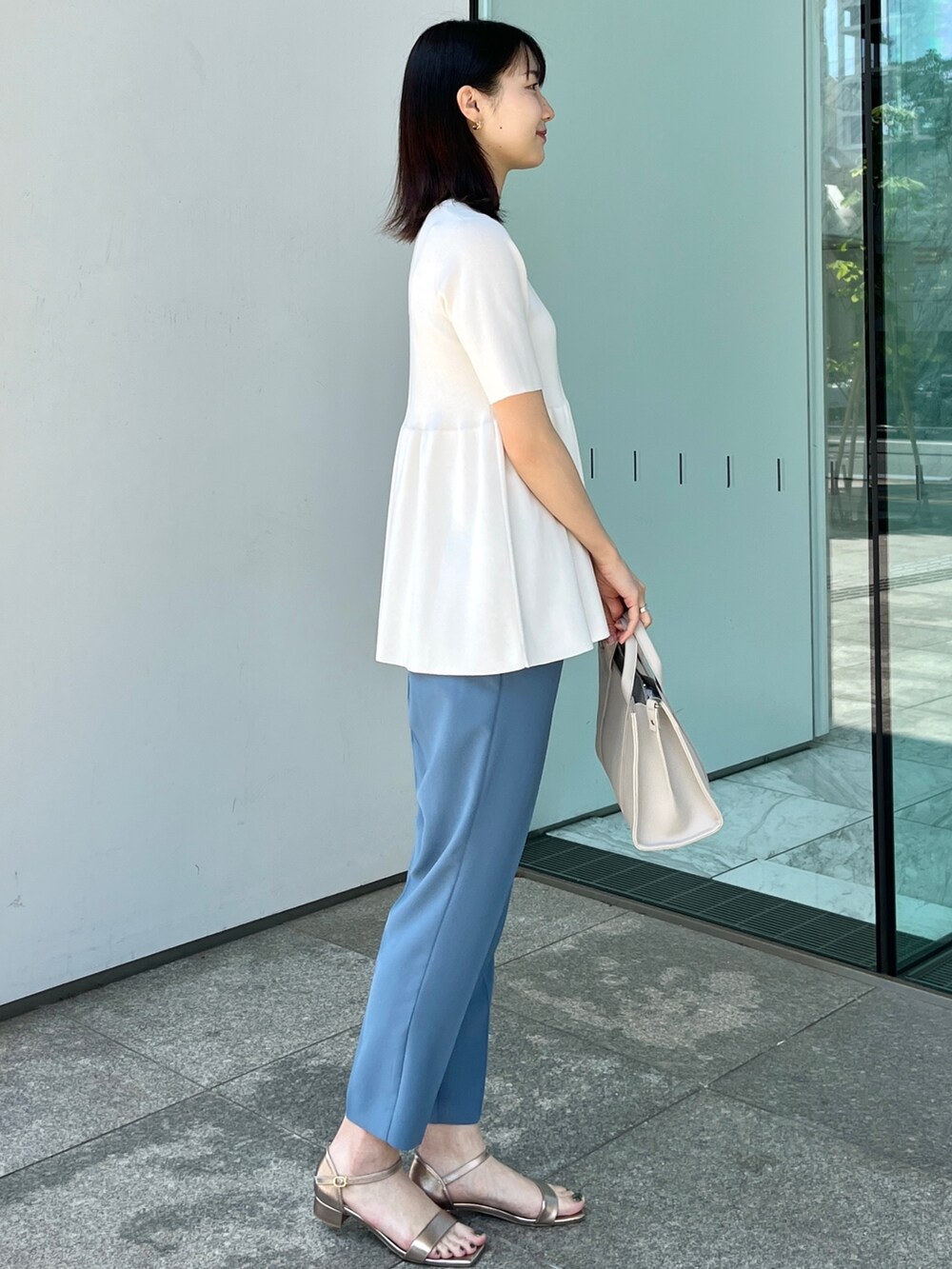 ホワイト系のニット/セーター、ブルー系のその他パンツ、ゴールド系のサンダルを着用したレディースの春コーディネートの2枚目の写真