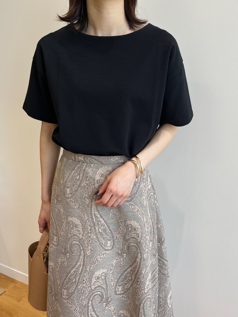 ブラウン系のサンダル、ベージュ系のスカート、イエロー系のトートバッグを着用したレディースの夏コーディネートの3枚目の写真