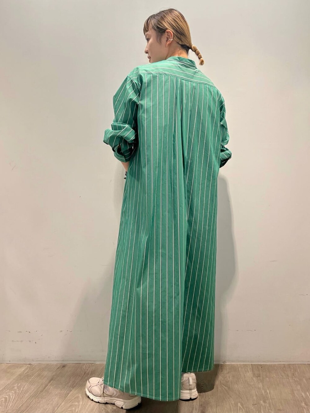 グリーン系のワンピース、ブラック系のショルダーバッグ、ホワイト系のネックレスを着用したレディースの秋コーディネートの2枚目の写真