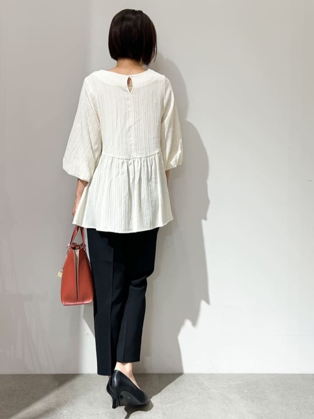 ホワイト系のシャツ/ブラウス、ブラック系のパンプス、レッド系のトートバッグを着用したレディースの夏コーディネートの5枚目の写真