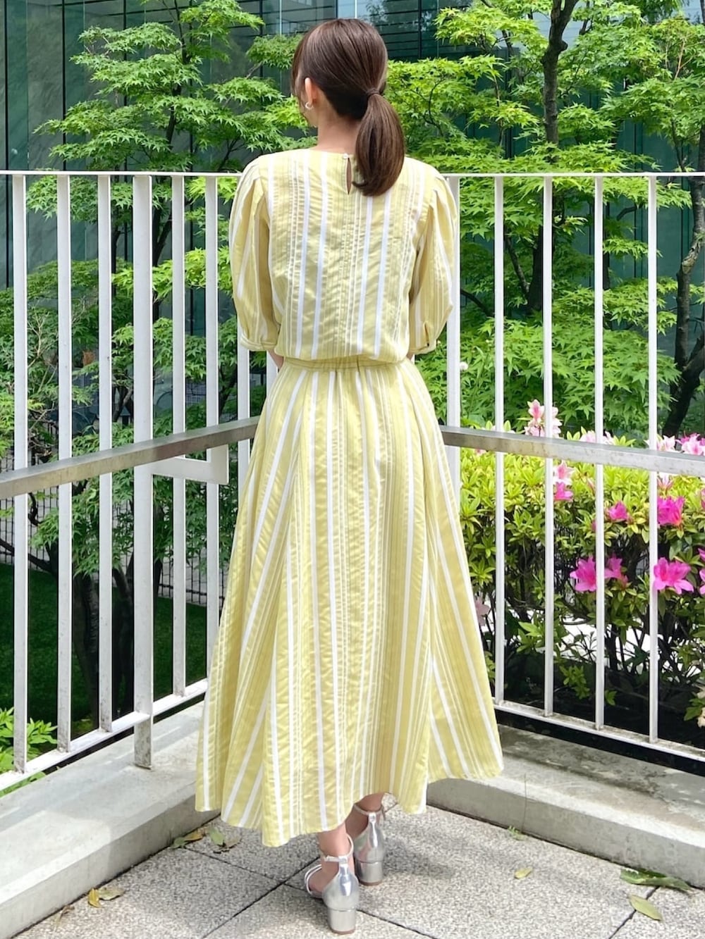 イエロー系のシャツ/ブラウス、イエロー系のスカート、シルバー系のサンダルを着用したレディースの春コーディネートの6枚目の写真