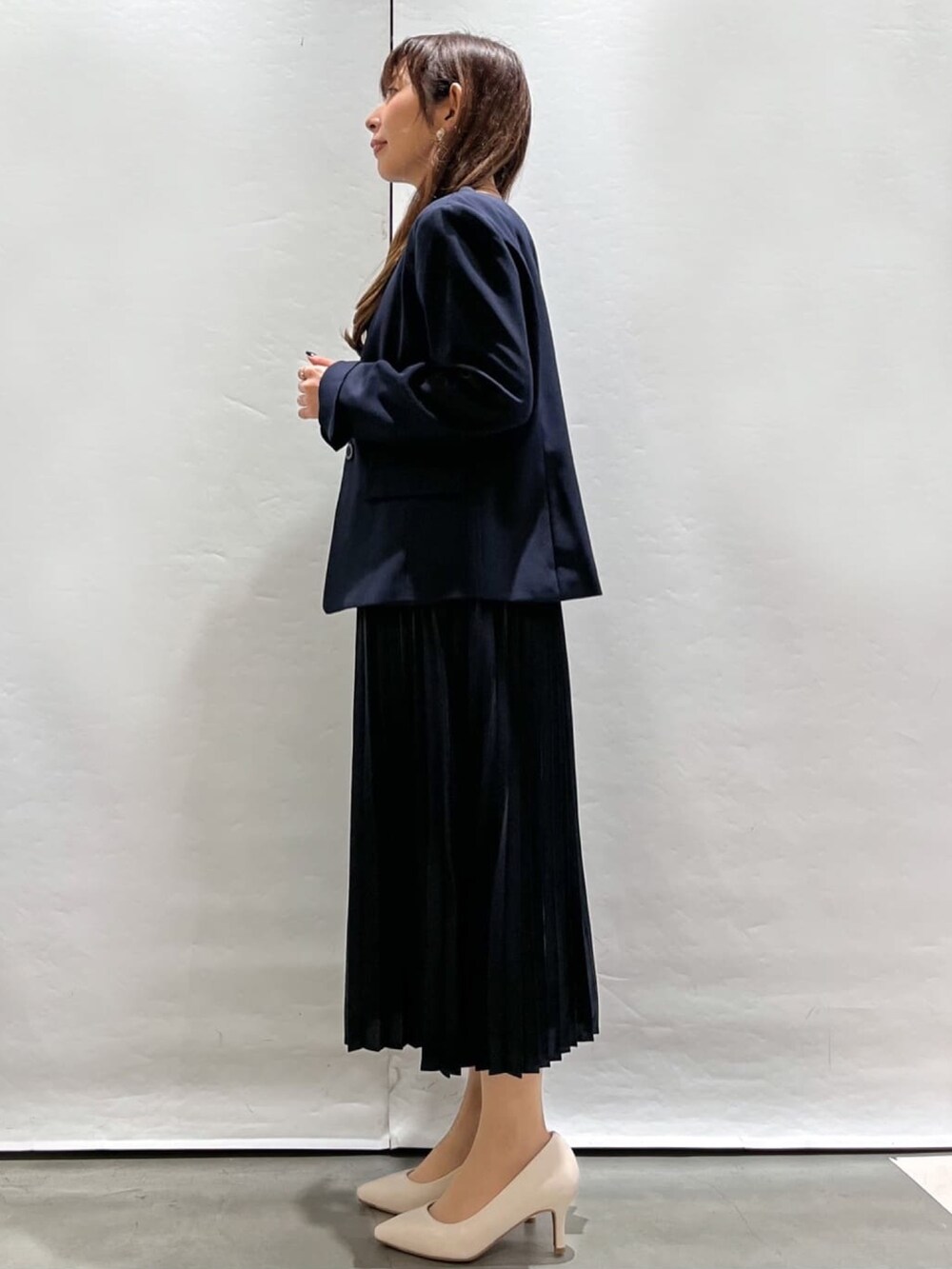 ブルー系のノーカラージャケット、ブルー系のワンピース、ホワイト系のパンプスを着用したレディースの春コーディネートの2枚目の写真