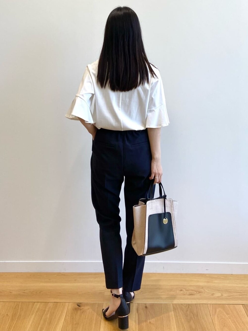 ホワイト系のTシャツ/カットソー、ブルー系のその他パンツ、ブラック系のトートバッグを着用したレディースの夏コーディネートの3枚目の写真