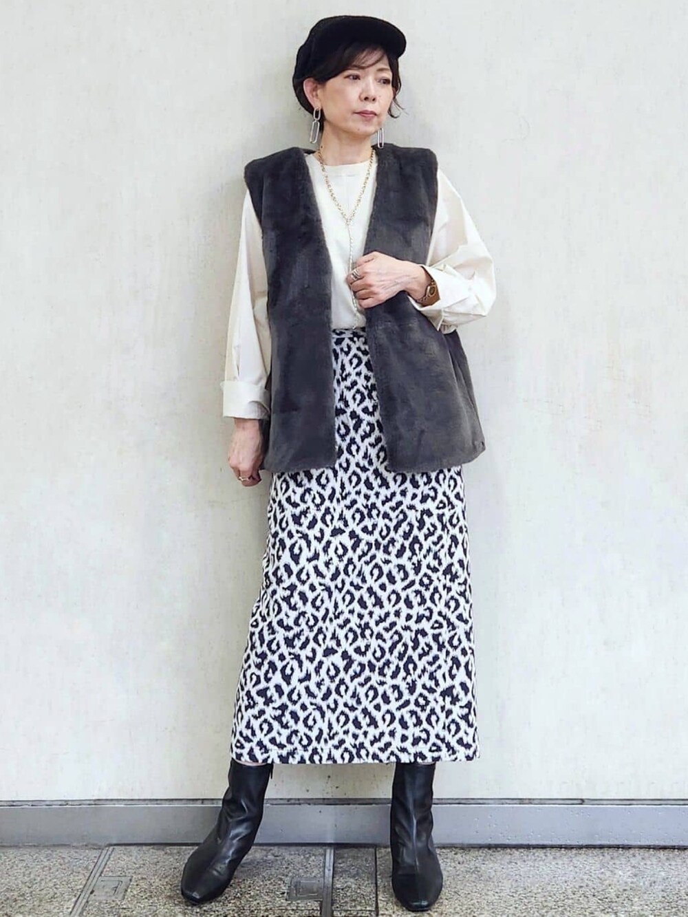 ブラック系のブルゾン、ブルー系のスカート、ブラック系のブーツを着用したレディースの秋コーディネートの6枚目の写真