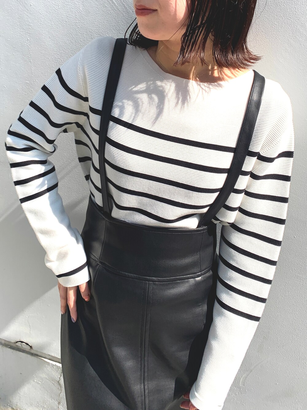 ホワイト系のニット/セーター、ブラック系のスカート、ブラック系のドレスシューズを着用したレディースの春コーディネートの3枚目の写真