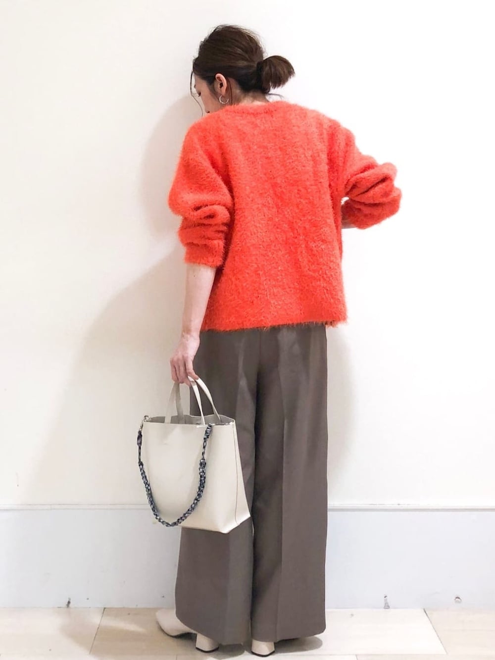 オレンジ系のカーディガン/ボレロ、ホワイト系のブーツ、ブラウン系のその他パンツを着用したレディースの秋コーディネートの3枚目の写真