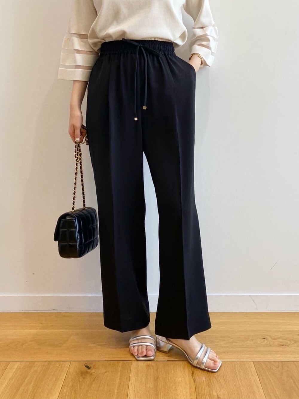 ホワイト系のニット/セーター、ブラック系のその他パンツ、ブラック系のショルダーバッグを着用したレディースの春コーディネートの10枚目の写真