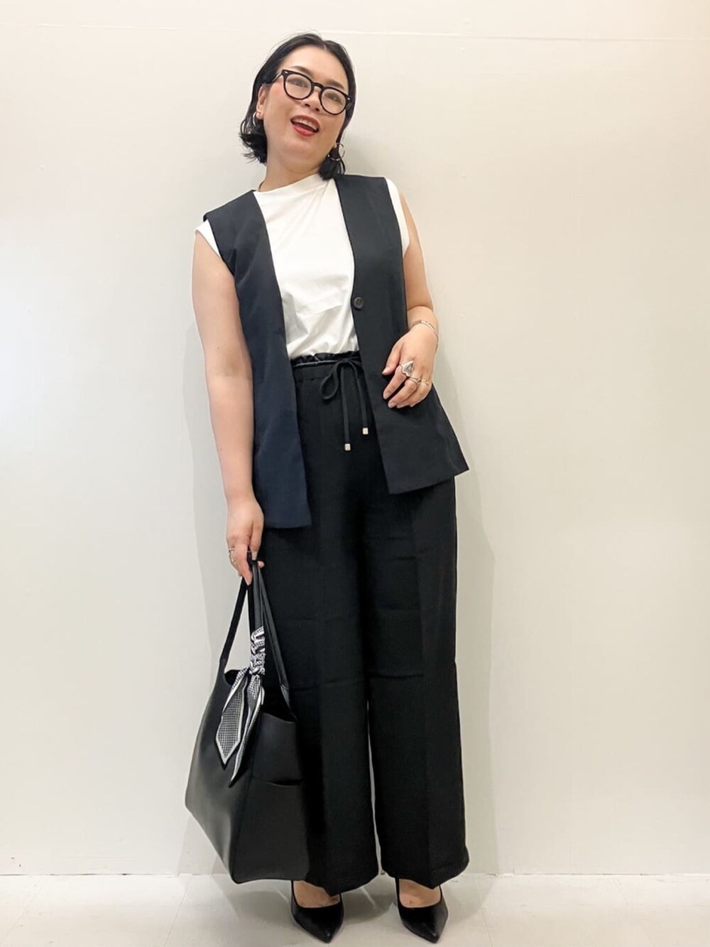 ホワイト系のTシャツ/カットソー、ブラック系のベスト、ブラック系のその他パンツを着用したレディースの夏コーディネートの3枚目の写真
